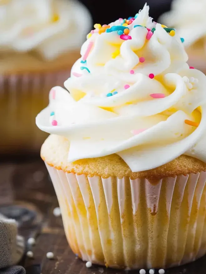 Perfect vanilla cupcakes with fluffy frosting on a cooling rack.