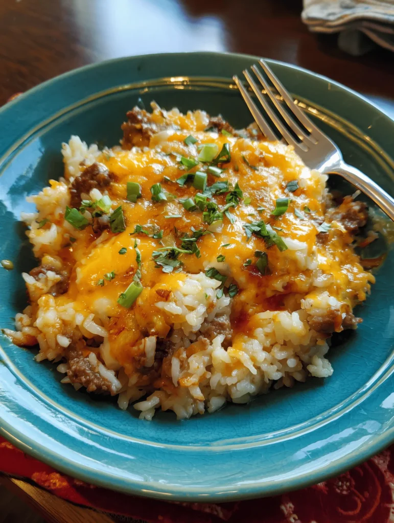 Delicious cheesy beef and rice casserole garnished with fresh herbs.