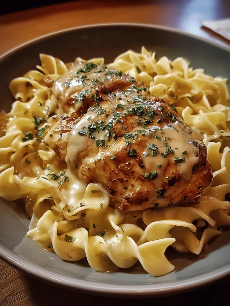 Delicious Chicken with Buttered Noodles served on a plate with herbs.